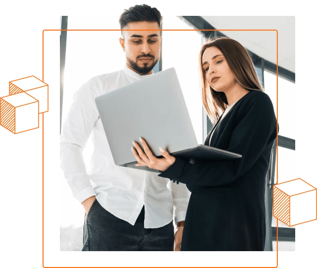 Photo of a woman and man looking at a laptop screen