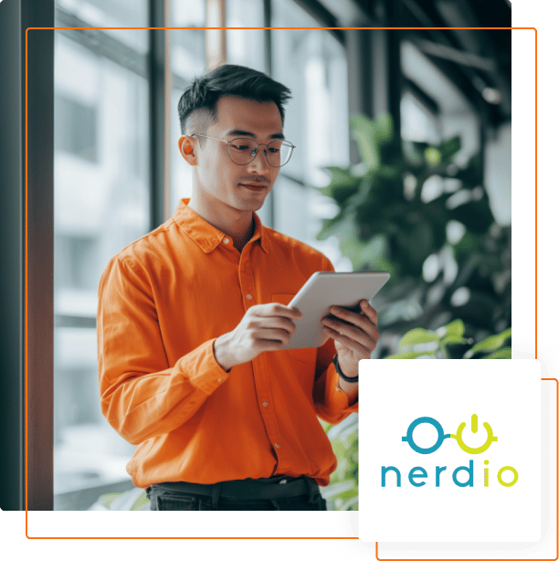 A person in an orange shirt holds a tablet, surrounded by plants and large windows, with a nerdio logo in the bottom corner.